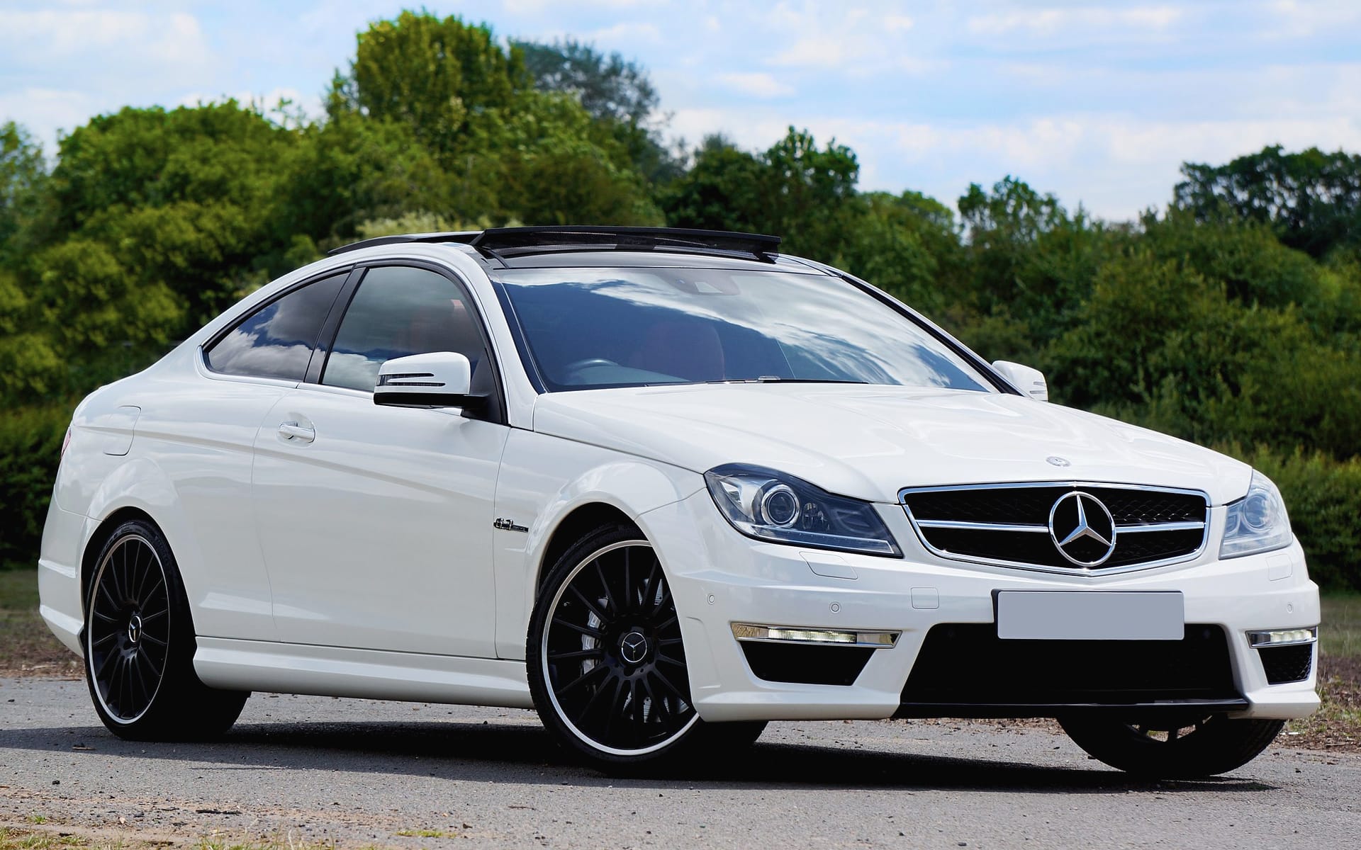 A white Mercedes-AMG C 63 Coupé with black wheels.
