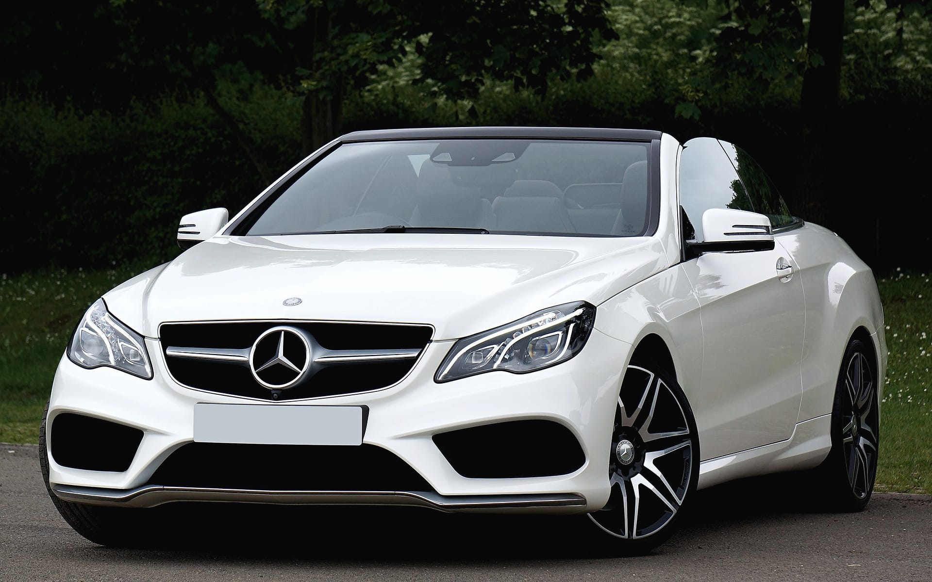 A white Mercedes E 400 Cabriolet with its roof up.