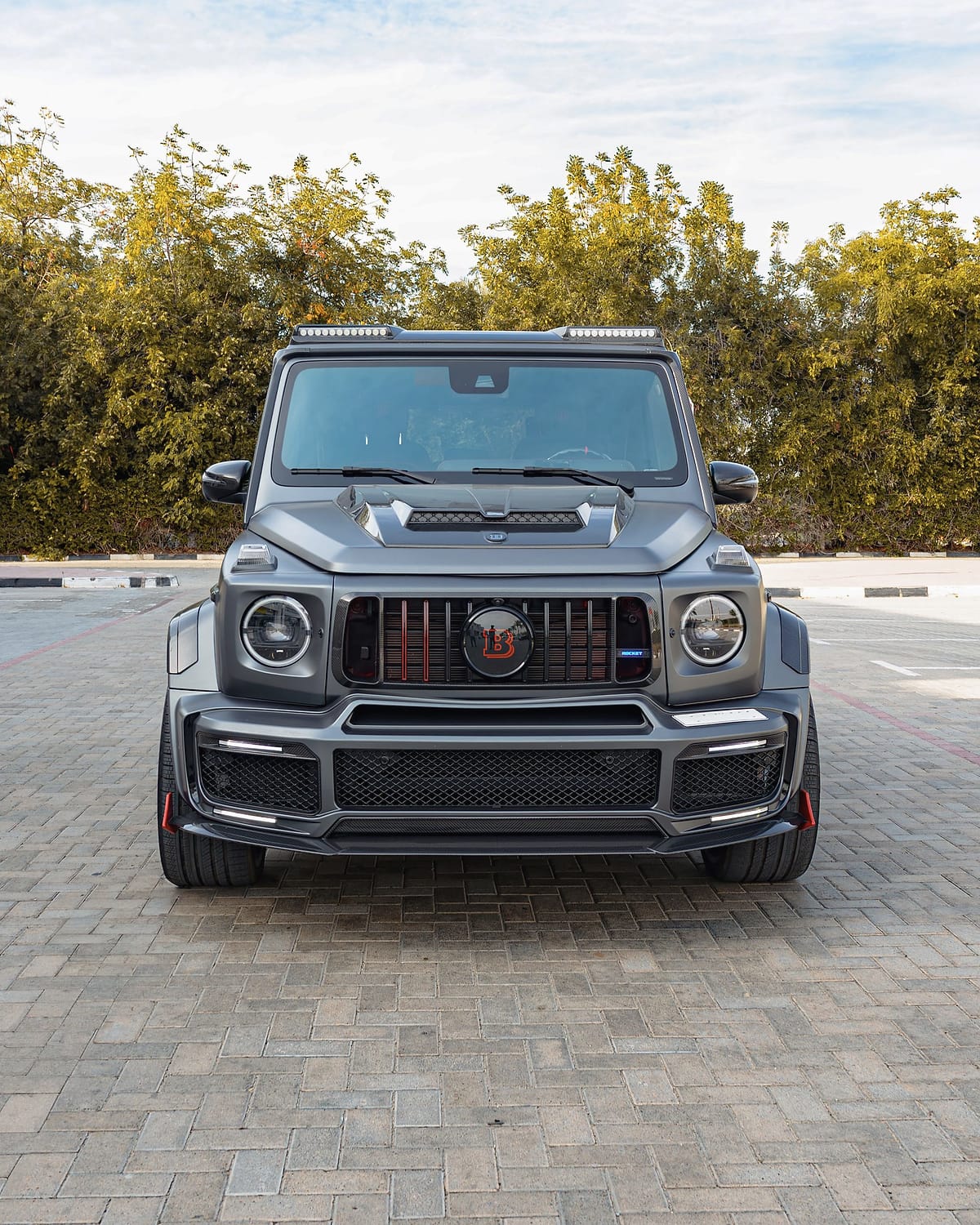The tuned G-Class head-on, with a bonnet scoop and red grille bars.