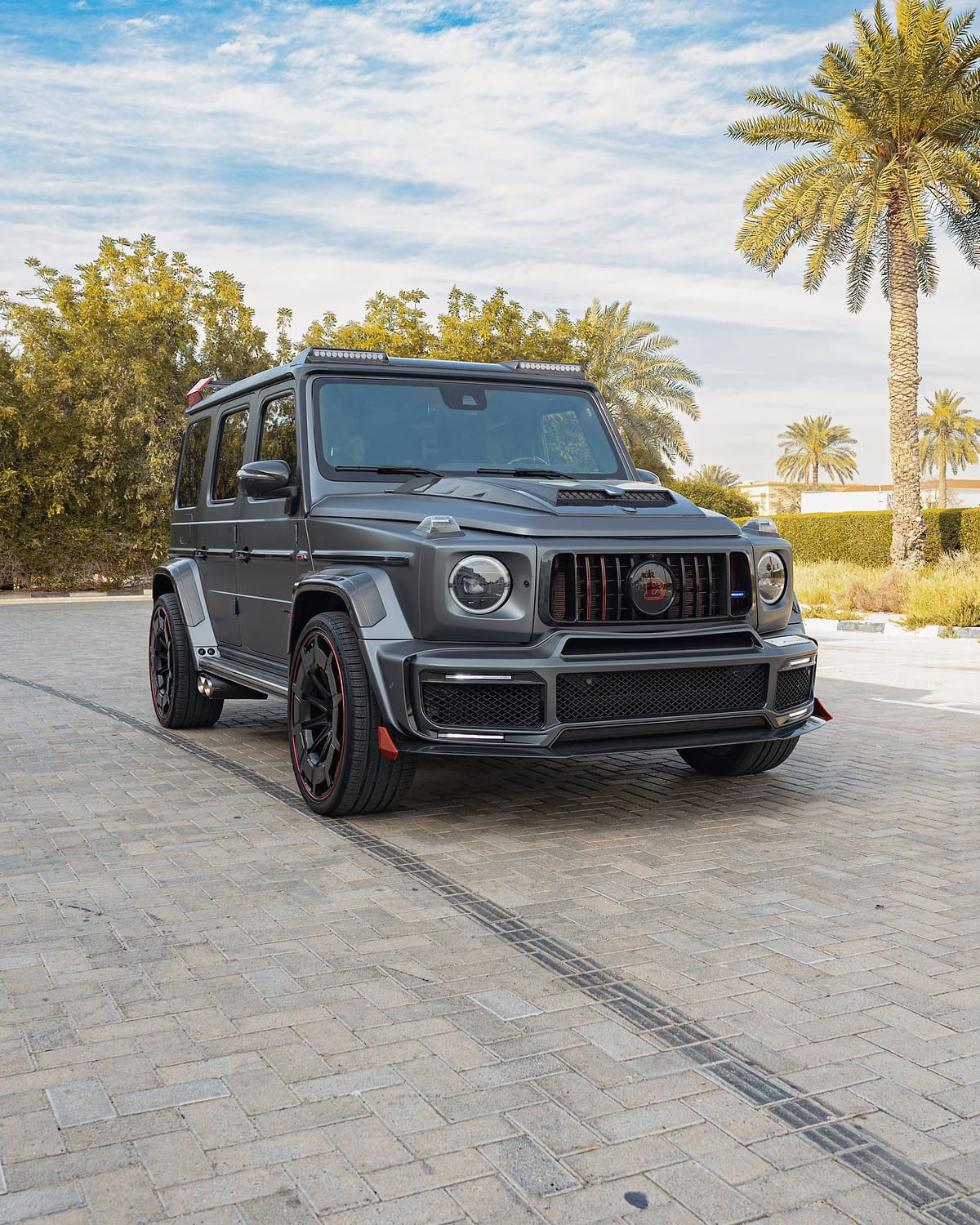 A matte grey Mercedes G-Class with an aftermarket body kit.