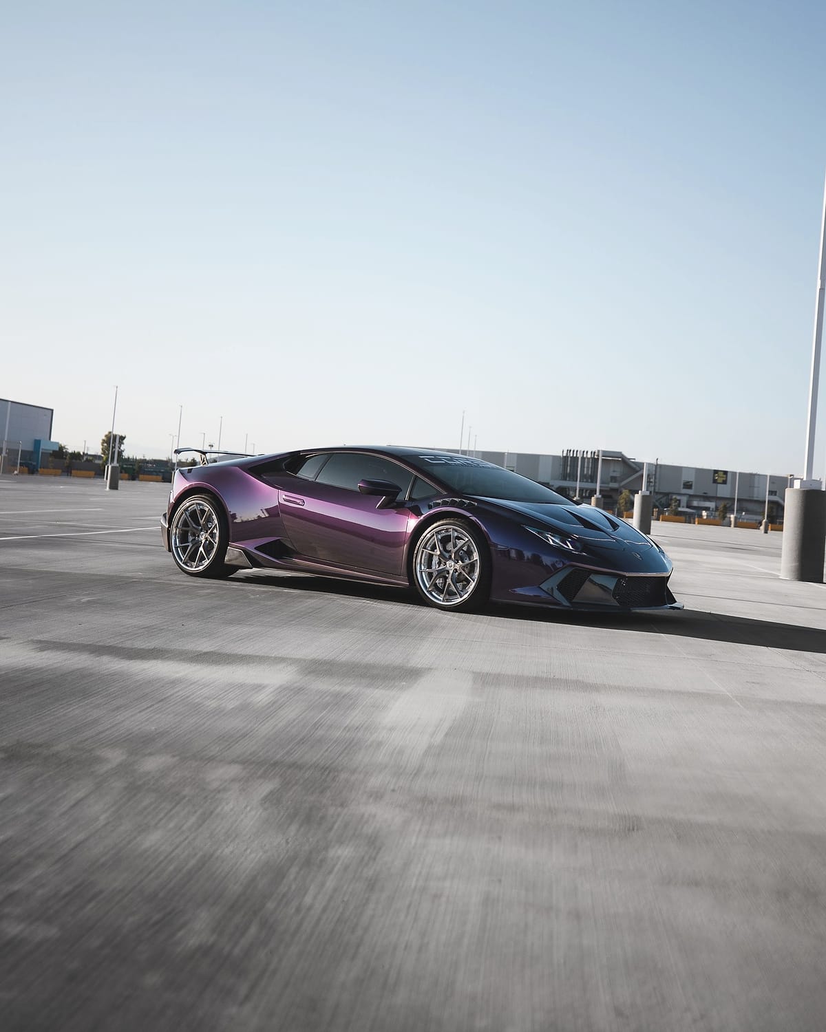 The purple Huracán from further back, low to the ground.