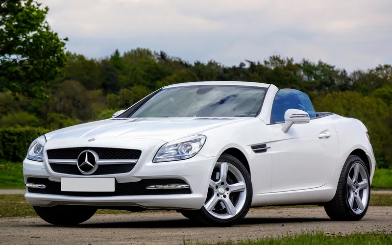 A white Mercedes-Benz SLK 250 with its roof down.